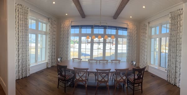 Pinch pleat draperies on traverse rods in a dining room