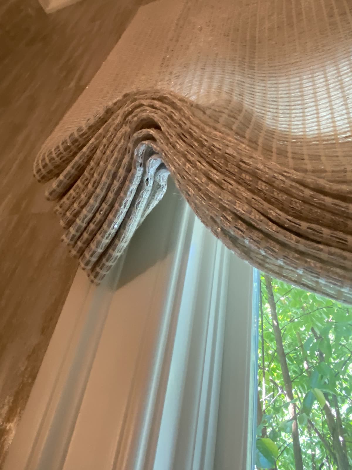 Dog ears on a relaxed Roman shade: soft folds hanging at the side