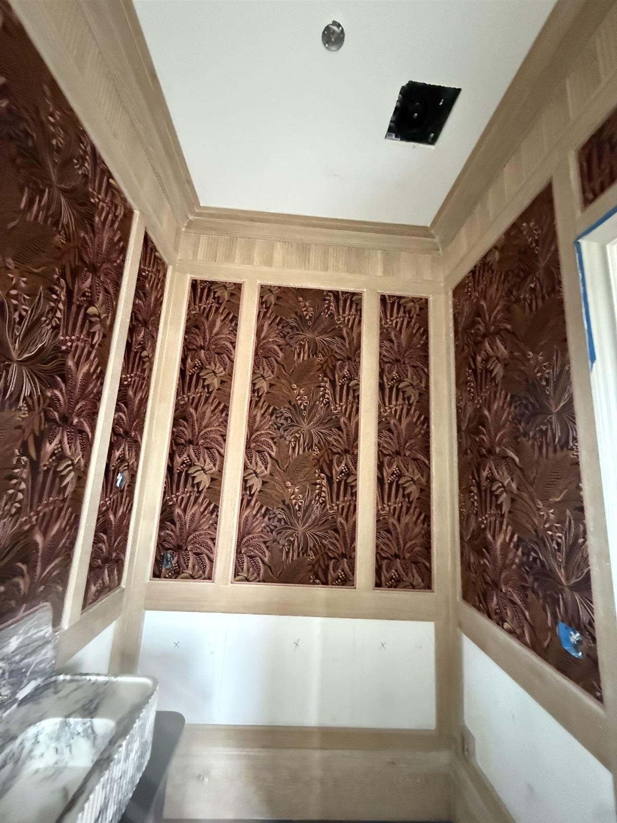 Fabric-upholstered wall panels set in oak moulding