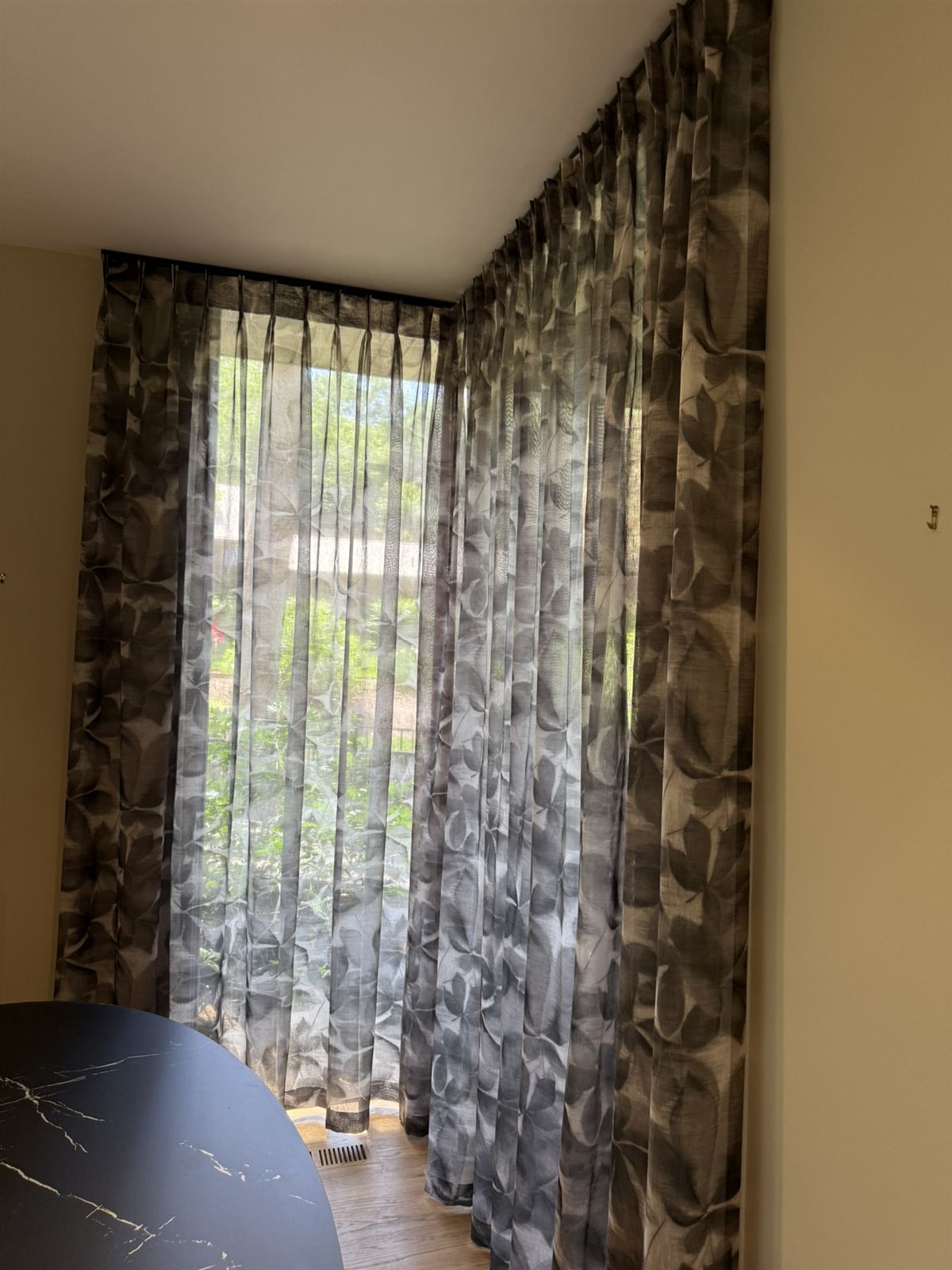 Pinch-pleated sheers at a garden window